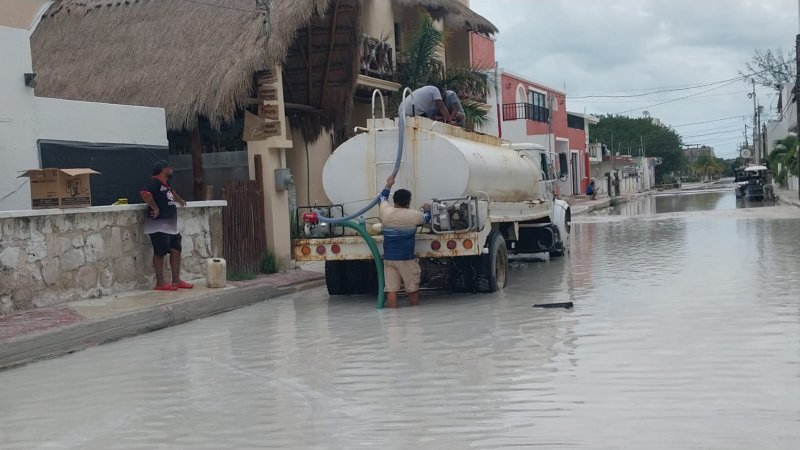 Desaguan calles encharcadas por torrenciales lluvias en Holbox.